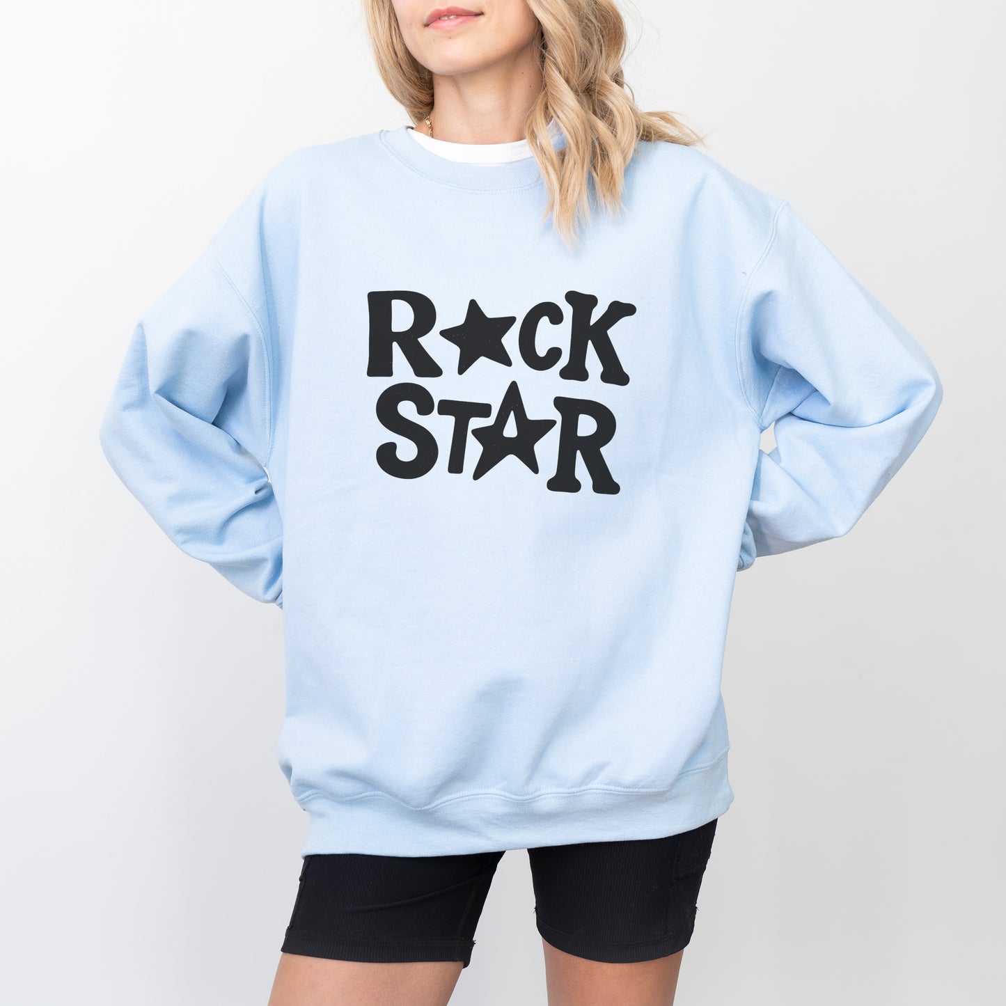A woman wearing a light blue sweatshirt with the text "ROCK STAR" printed on it.