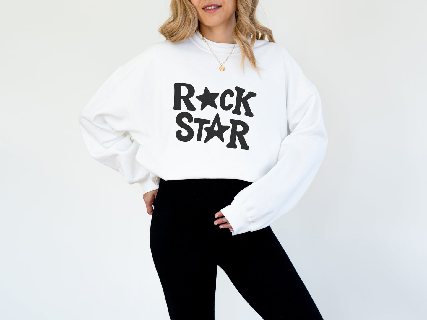 A woman wearing a white sweatshirt with the text "ROCK STAR" printed on it.