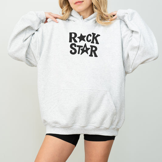 A woman wearing a grey hoodie with the text "ROCK STAR" printed on it.